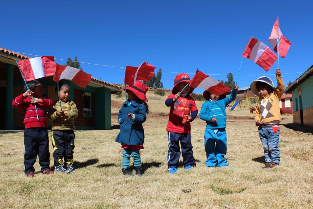Bambini sulle Ande con bandierine del Perù
