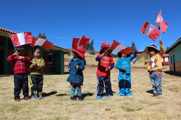 Bambini sulle Ande con bandierine del Perù